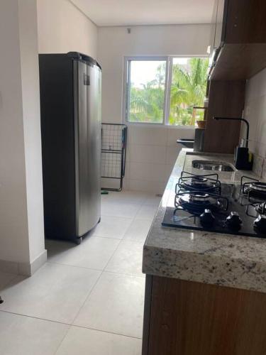 a kitchen with a stove and a stainless steel refrigerator at Apto próximo ao Shopping in Umuarama