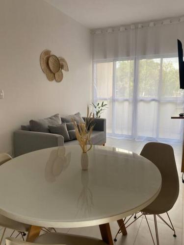 uma mesa branca e cadeiras numa sala de estar em Apto próx centro e faculdade em Umuarama