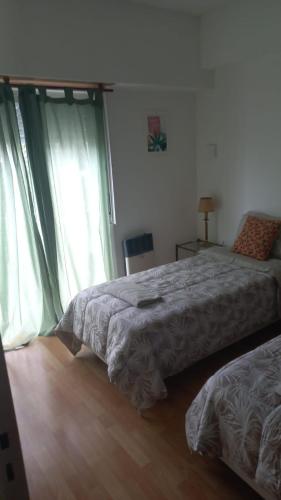 a bedroom with two beds and a window at Departamento Céntrico Zona Basílica de Luján in Luján