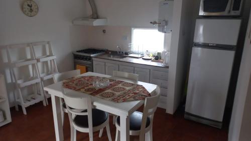 a kitchen with a white table and a white refrigerator at Departamento Céntrico Zona Basílica de Luján in Luján