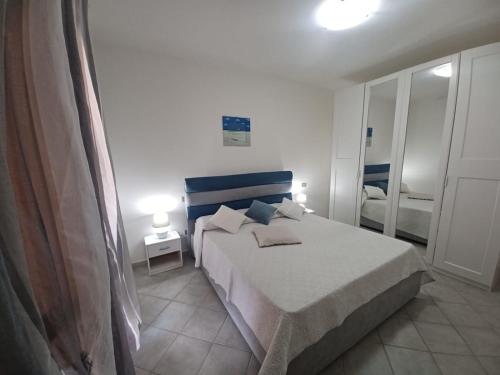um quarto com uma cama com uma cabeceira azul em CASA SIBILLA bi-locale con terrazza a 60 metri dal mare em Marinella