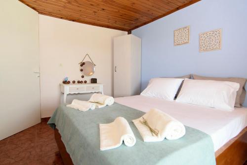 1 dormitorio con 1 cama con toallas en Aoria Traditional House, en Loúlos