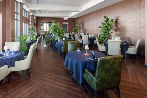 uma sala de jantar com mesas azuis e cadeiras verdes em Legacy Hotel, Trademark Collection by Wyndham em Green Bay