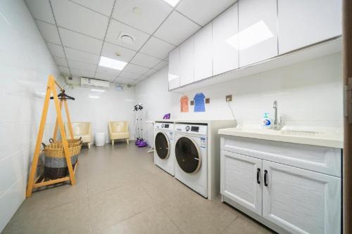 a laundry room with a washer and dryer in it at Hanting Hotel Shanghai Jiading New Town Malu in Jiading