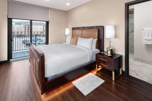 um quarto com uma cama grande e uma varanda em Legacy Hotel, Trademark Collection by Wyndham em Green Bay