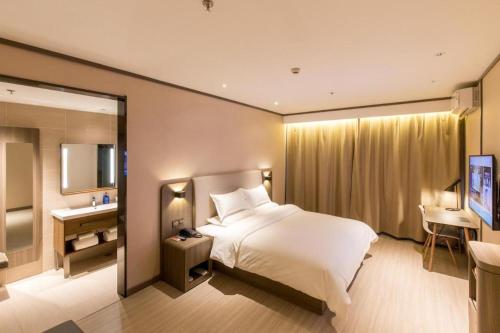 Un pat sau paturi într-o cameră la Hanting Hotel Shijiazhuang Shengli Bei Street