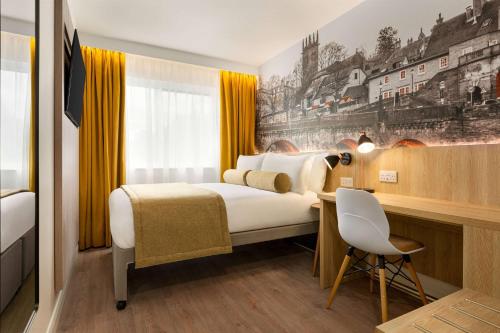 ein Hotelzimmer mit einem Bett und einem Schreibtisch in der Unterkunft Super 8 by Wyndham Durham in Durham