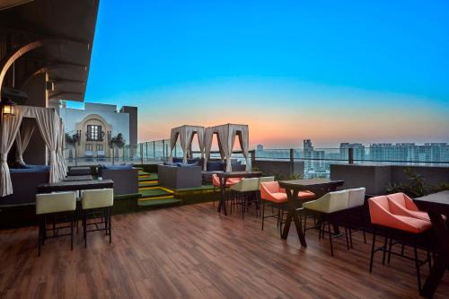 a rooftop bar with tables and chairs on a building at DoubleTree by Hilton Gurugram Baani Square in Gurgaon