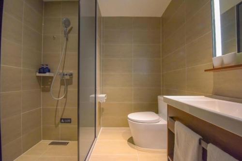 a bathroom with a shower and a toilet and a sink at Hanting Hotel Shijiazhuang Xingtang Longzhou West Street in Xingtang