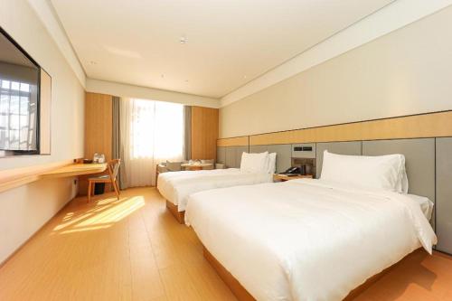 Posteľ alebo postele v izbe v ubytovaní Ji Hotel Qingshan Lake Hongdu North Avenue