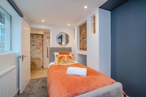 een slaapkamer met een bed met een oranje deken bij 2 Bedroom 2Bathroom I Next To Brighton Beach I Sleep 6 in Brighton & Hove