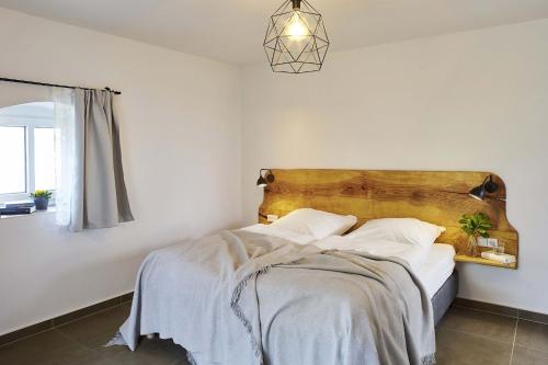 a bedroom with a bed with a wooden headboard at Hexenhaus in Rietz Neuendorf