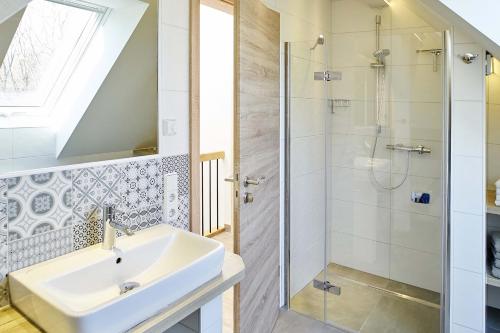 La salle de bains est pourvue d'un lavabo et d'une douche. dans l'établissement Alte Scheune, à Rietz Neuendorf