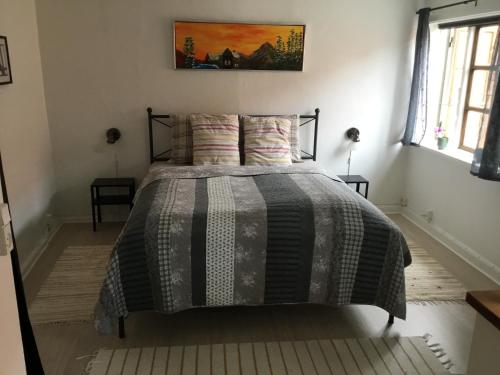 um quarto com uma cama com um edredão preto e cinzento em Stubbekøbingrooms em Stubbekøbing