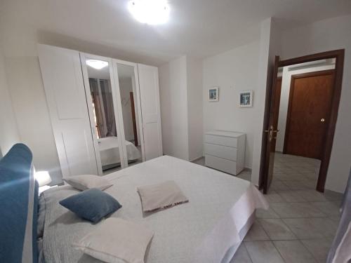 a white bedroom with a bed and a mirror at CASA SIBILLA bi-locale con terrazza a 60 metri dal mare in Marinella