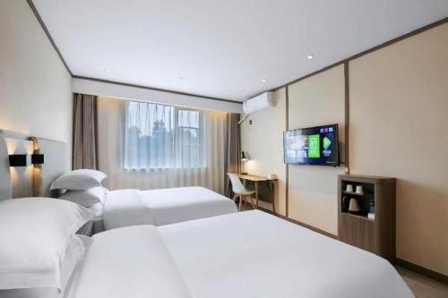 En eller flere senge i et værelse på Hanting Hotel Baotou East Railway Station Zhanqian Square