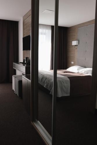 a hotel room with a bed and a mirror at VILSON hotel in Bukovel