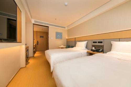 Un pat sau paturi într-o cameră la Ji Hotel Shanghai Huangxing Road Metro Station