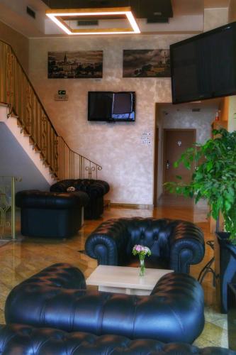 a lobby with leather couches and a table and a staircase at Euro Garni Hotel in Belgrade