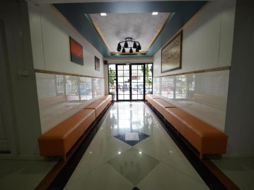 uma sala de espera com bancos laranja num edifício em RoomQuest Prachin Buri Rojana em Ban Nong Sai Yong