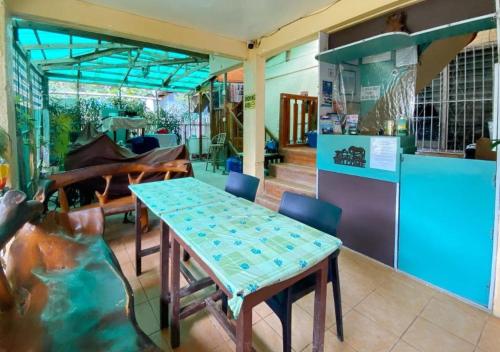 RedDoorz Hostel @ Bunakidz Lodge El Nido Palawan في Santa Monica: طاولة وكراسي في غرفة مع مطبخ