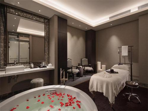 a hotel room with a bath tub and a bed at Song Hotel Jinan Fengming in Hongjialou