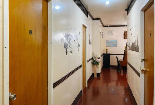 um corredor que leva a um quarto com uma pintura na parede em RedDoorz Hostel @ Bunakidz Lodge El Nido Palawan em Santa Monica