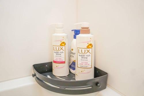 three bottles of shampoo and conditioner in a metal holder at Direct to Namba,Korean town201 in Osaka