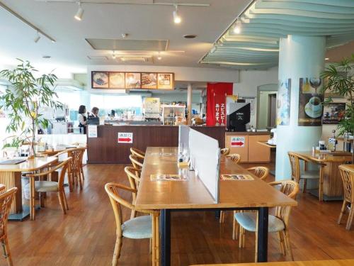 TogitsuにあるTogitsu Yasuda Ocean Hotelの木製のテーブルと椅子、カウンターが備わるレストラン
