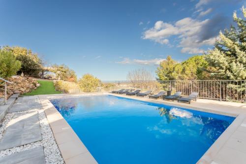 une piscine avec des chaises et une clôture dans l'établissement La Bastide des Albères, à Villelongue-dels-Monts