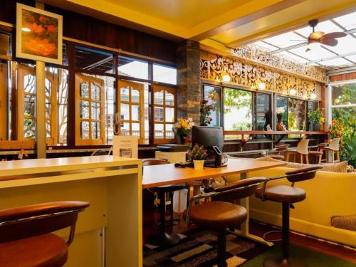 restauracja ze stołem, krzesłami i oknami w obiekcie AIRBEST HOTEL w mieście Ban Chang