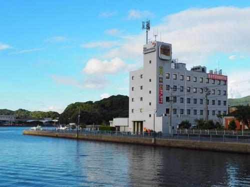 ein großes weißes Gebäude neben einem Wasserkörper in der Unterkunft Togitsu Yasuda Ocean Hotel in Togitsu