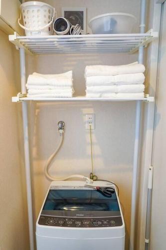 a kitchen with a stove and towels on a shelf at Direct to Namba,Korean town201 in Osaka