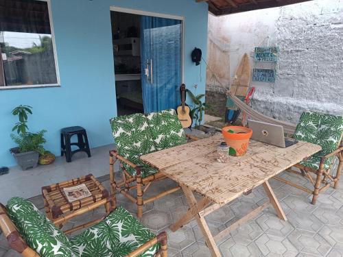 a table and chairs with a laptop on a patio at Kitnets Renascer Beach in Guaibim