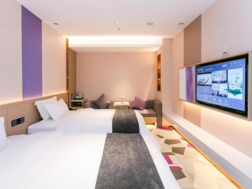 Habitación de hotel con cama grande y TV de pantalla plana. en Lavande Hotel Huizhou World Trade Center en Huizhou
