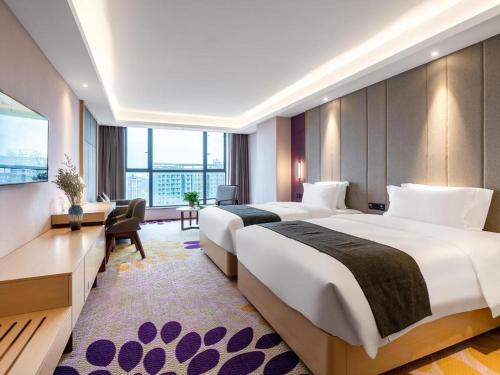 a hotel room with two beds and a desk at Lavande Hotel Zunyi Times Tianjie in Zunyi