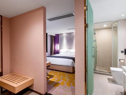 a bedroom with a bed and a bathroom with a shower at Lavande Hotel Zunyi Times Tianjie in Zunyi
