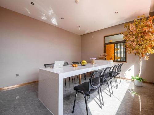 a kitchen with a table with chairs and a laptop at Lavande Hotel Kunming West Mountain Wanda Plaza in Kunming