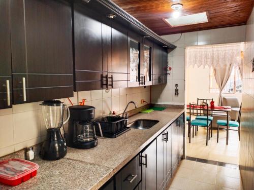 a kitchen with black cabinets and a counter top at Apartamento Familiar Privado 101 Con Baño Cocina Tv Wifi Sala in Salento