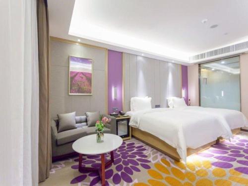 - une chambre avec un grand lit et un canapé dans l'établissement Lavande Hotel Huizhou Shiwan, à Shiwan