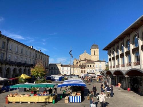 Un groupe de personnes se promenant autour d'un marché dans une ville dans l'établissement Superbe T3 dans le quartier historique de Marmande, à Marmande