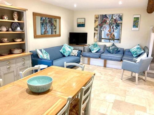 sala de estar con sofá azul y mesa en Luxury Country Bolthole Near Soho Farmhouse, en Middle Barton