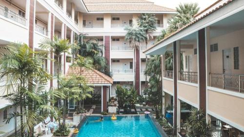apartamentowiec z basenem i palmami w obiekcie Nattida Place w mieście Chiang Mai