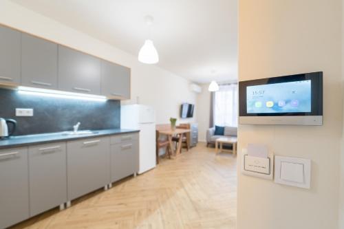 a kitchen with white cabinets and a tv on a wall at WOW studios for rent 2 bul Montevideo 25A - B in Sofia