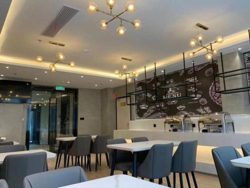 un restaurante con mesas, sillas y una barra en Green Tree Inn Express Chizhou Gymnasium, en Pai-sha-p'u