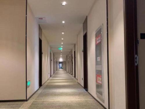 un pasillo vacío de un edificio de oficinas con un pasillo largo en Green Tree Inn Express Chizhou Gymnasium, en Pai-sha-p'u