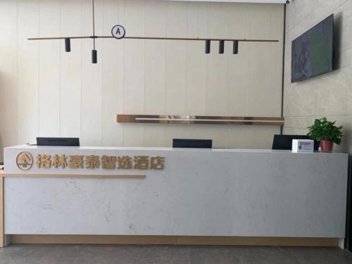 Green Tree Inn Express Chizhou Gymnasium في Pai-sha-p'u: مكتب استقبال في مبنى عليه لافته