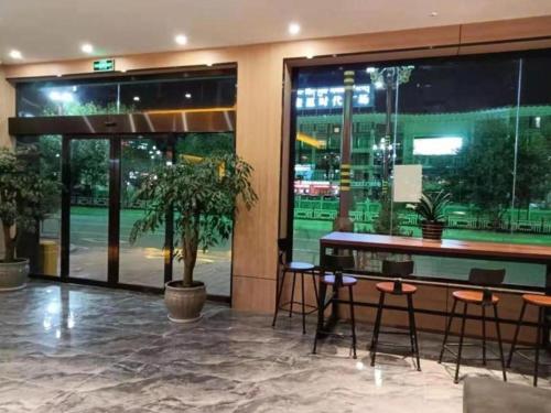 Markam的住宿－Green Tree Inn Express Xizang Changdu Mangkang County，大堂内带凳子的酒吧