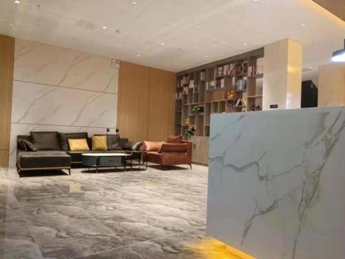 a lobby with couches and a marble wall at Green Tree Inn Express Xizang Changdu Mangkang County in Markam