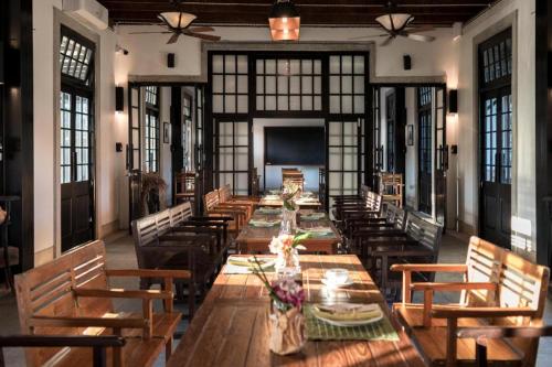 a large dining room with a long table and chairs at Uthai Heritage Hotel in Ban Nong Nam Khan